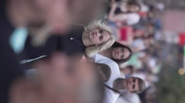 KYIV, UKRAINE 30 AĞUSTOS 2024: Yazın bir şehir caddesinde kalabalığın dikey videosu.