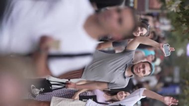 KYIV, UKRAINE 30 AĞUSTOS 2024: Yazın bir şehir caddesinde kalabalığın dikey videosu.