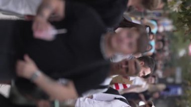 KYIV, UKRAINE 30 AĞUSTOS 2024: Yazın bir şehir caddesinde kalabalığın dikey videosu.