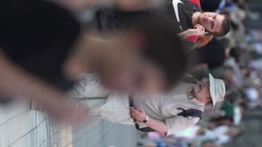 KYIV, UKRAINE 30 AĞUSTOS 2024: Yazın bir şehir caddesinde kalabalığın dikey videosu.