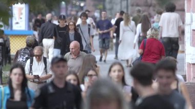 KYIV, UKRAINE - 25 Ağustos 2024: Şehir caddesi yazın insanlarla dolu, ağır çekim