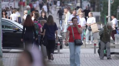 KYIV, UKRAINE - 25 Ağustos 2024: Şehir caddesi yazın insanlarla dolu, ağır çekim