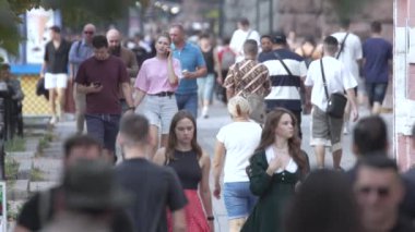 KYIV, UKRAINE 25 AĞUSTOS 2024: İnsanlar yazın yavaş çekimde cadde boyunca yürür