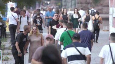 KYIV, UKRAINE 25 AĞUSTOS 2024: İnsanlar yazın yavaş çekimde cadde boyunca yürür