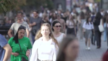 KYIV, UKRAINE 25 AĞUSTOS 2024: İnsanlar yazın yavaş çekimde cadde boyunca yürür