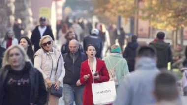 KYIV, UKRAINE 6 Ekim 2024: İnsanlar sonbaharda cadde boyunca ağır çekimde yürür