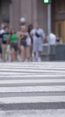 KYIV, UKRAINE 21 Ekim 2024: Yaya geçidindeki bir kalabalığın dikey videosu, yavaş çekim