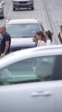 KYIV, UKRAINE 21 Ekim 2024: Yaya geçidindeki bir kalabalığın dikey videosu, yavaş çekim