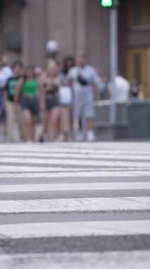 KYIV, UKRAINE 21 Ekim 2024: Yaya geçidindeki bir kalabalığın dikey videosu, yavaş çekim