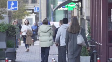 KYIV, UKRAINE - 6 Ekim 2024: İnsanlar sonbaharda cadde boyunca ağır çekimde yürürler