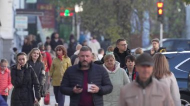 KYIV, UKRAINE - 6 Ekim 2024: Birçok insan sonbaharda yavaş çekimde caddede yürür