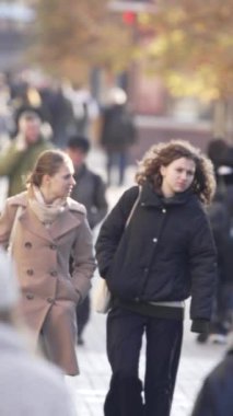KYIV, UKRAINE - 6 Ekim 2024: Sonbaharda insanlarla dolu bir şehir sokağının dikey videosu, yavaş çekim