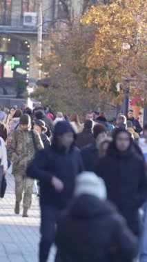 KYIV, UKRAINE - 6 Ekim 2024: Sonbaharda bir şehir caddesinde kalabalığın dikey videosu.