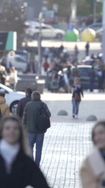 KYIV, UKRAINE - 6 Ekim 2024: Sonbaharda bir şehir caddesinde kalabalığın dikey videosu.