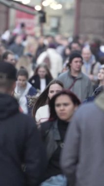 KYIV, UKRAINE - 6 Ekim 2024: Sonbaharda insanlarla dolu bir şehir sokağının dikey videosu, yavaş çekim