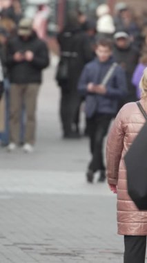 KYIV, UKRAINE - 6 Ekim 2024: Sonbaharda insanlarla dolu bir şehir sokağının dikey videosu, yavaş çekim