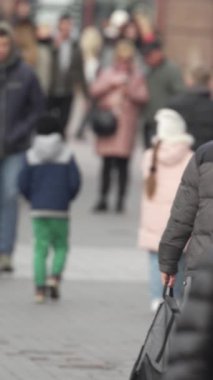 KYIV, UKRAINE - 6 Ekim 2024: Sonbaharda bir şehir caddesinde kalabalığın dikey videosu.