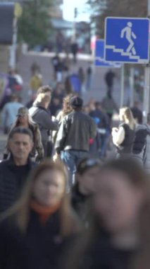 KYIV, UKRAINE - 6 Ekim 2024: Sonbaharda bir şehir caddesinde kalabalığın dikey videosu.