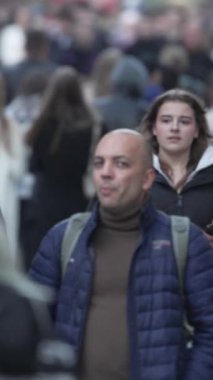 KYIV, UKRAINE - 6 Ekim 2024: Sonbaharda bir şehir caddesinde kalabalığın dikey videosu.