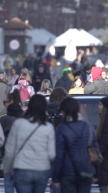 KYIV, UKRAINE ECTOBER 6, 2024: Sonbaharda cadde boyunca yürüyen insanların dikey videosu, yavaş çekim