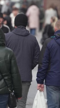 KYIV, UKRAINE ECTOBER 6, 2024: Sonbaharda cadde boyunca yürüyen insanların dikey videosu, yavaş çekim