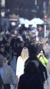 KYIV, UKRAINE ECTOBER 6, 2024: Sonbaharda cadde boyunca yürüyen insanların dikey videosu, yavaş çekim