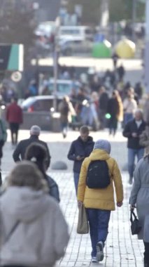 KYIV, UKRAINE 6 Ekim 2024: Sonbaharda bir şehir caddesinde kalabalığın dikey videosu.
