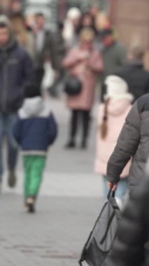 KYIV, UKRAINE - 6 Ekim 2024: Sonbaharda insanlarla dolu bir şehir sokağının dikey videosu, yavaş çekim