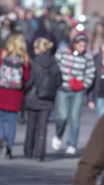 KYIV, UKRAINE - 6 Ekim 2024: Birçok insanın sonbaharda yavaş çekimde sokakta yürüdüğü dikey video