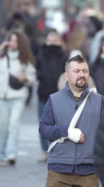 KYIV, UKRAINE - 6 Ekim 2024: Sonbaharda sokakta yürüyen insanların dikey videosu, yavaş çekim