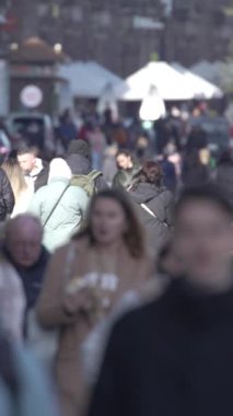 KYIV, UKRAINE - 6 Ekim 2024: Sonbaharda insanlarla dolu bir şehir sokağının dikey videosu, yavaş çekim