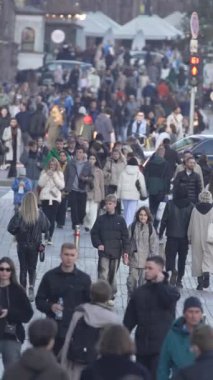 KYIV, UKRAINE - 6 Ekim 2024: Sonbaharda insanlarla dolu bir şehir sokağının dikey videosu, yavaş çekim