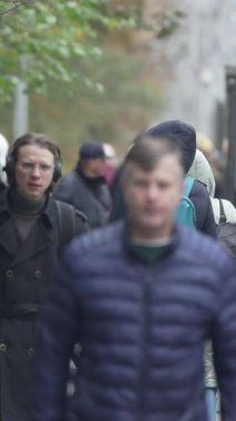 KYIV, UKRAINE - 6 Ekim 2024: Sonbaharda insanlarla dolu bir şehir sokağının dikey videosu, yavaş çekim