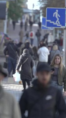 KYIV, UKRAINE - 6 Ekim 2024: Sonbaharda insanlarla dolu bir şehir sokağının dikey videosu, yavaş çekim