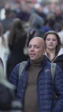 KYIV, UKRAINE - 6 Ekim 2024: Sonbaharda bir şehir caddesinde kalabalığın dikey videosu.
