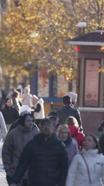 KYIV, UKRAINE - 6 Ekim 2024: Sonbaharda bir şehir caddesinde kalabalığın dikey videosu.