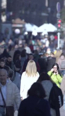 KYIV, UKRAINE - 6 Ekim 2024: Birçok insanın sonbaharda yavaş çekimde sokakta yürüdüğü dikey video