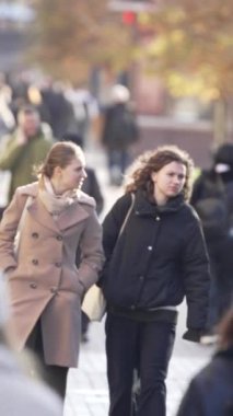 KYIV, UKRAINE - 6 Ekim 2024: Birçok insanın sonbaharda yavaş çekimde sokakta yürüdüğü dikey video