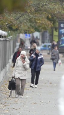 KYIV, UKRAINE - 6 Ekim 2024: Sonbaharda Ukrayna 'nın Kyiv kentinde kalabalık bir caddenin dikey videosu