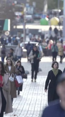 KYIV, UKRAINE - 6 Ekim 2024: Sonbaharda bir şehir caddesinde kalabalığın dikey videosu