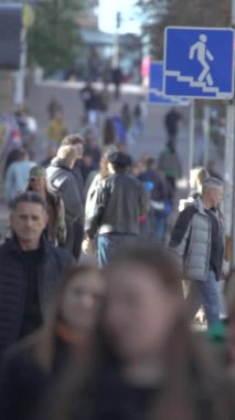 KYIV, UKRAINE - 6 Ekim 2024: Birçok insanın sonbaharda yavaş çekimde sokakta yürüdüğü dikey video