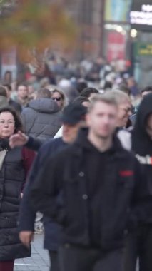 KYIV, UKRAINE - 6 Ekim 2024: Birçok insanın sonbaharda yavaş çekimde sokakta yürüdüğü dikey video