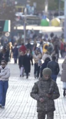 KYIV, UKRAINE - 6 Ekim 2024: Birçok insanın sonbaharda yavaş çekimde sokakta yürüdüğü dikey video