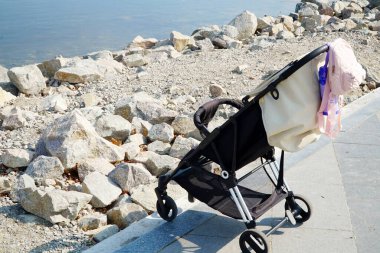 Nehir kenarındaki parkta bir çocuk için bebek arabası.  