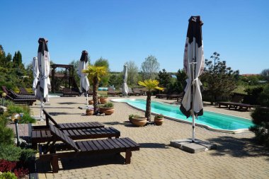 Yazın dinlenmek için havuz kenarında güneşlenirler.             