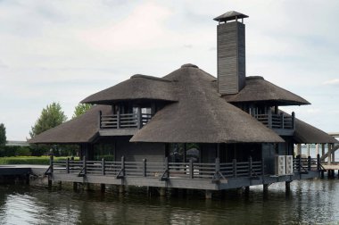 Sazdan çatılı ayaklıklarda bir ev               