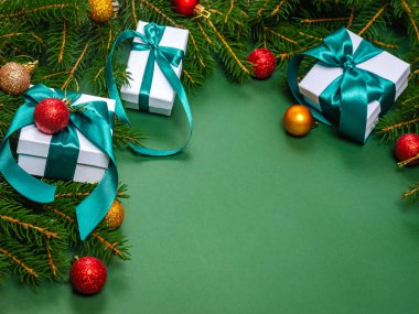 Noel hediye kutuları, köknar dalları ve Noel oyuncakları olan yeşil bir arka planda. Noel kartı. Tatil zamanı. - Mutlu yıllar. Mesaj için yer. Yaklaş, düz yat..