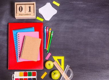 Egzersiz kitapları, 1 Eylül tarihli ahşap takvim, siyah arka planda kırtasiye. Okul hazırlığı konsepti, düz yatak, fotokopi alanı, yazı için yer. Yukarıdan görüntüle.