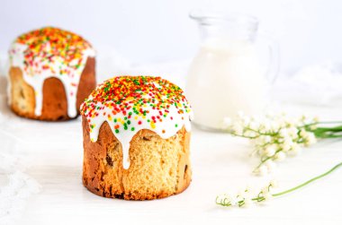 Beyaz arkaplanda beyaz şekerli süsleme ve renkli şekerleme ile süslenmiş Paskalya pastası. İlkbaharda geleneksel mevsimlik pişirme. Paskalya bayramı kutlaması. Yakın plan..