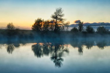 Manawatu Nehri 'nin sabah sisi yansıtıcı nehir suyunun üzerindedir..